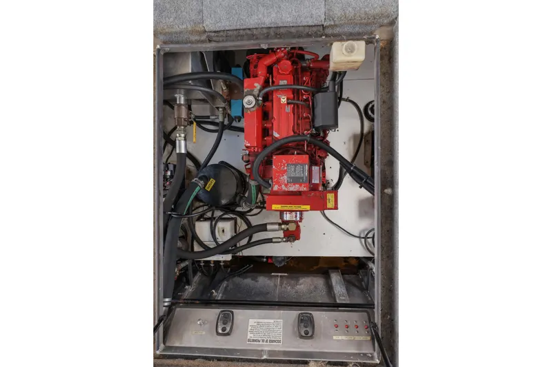 Slide: The Image of Engine compartment of a 2002 Sumerset 16x75 houseboat, featuring red machinery and wiring. - 44