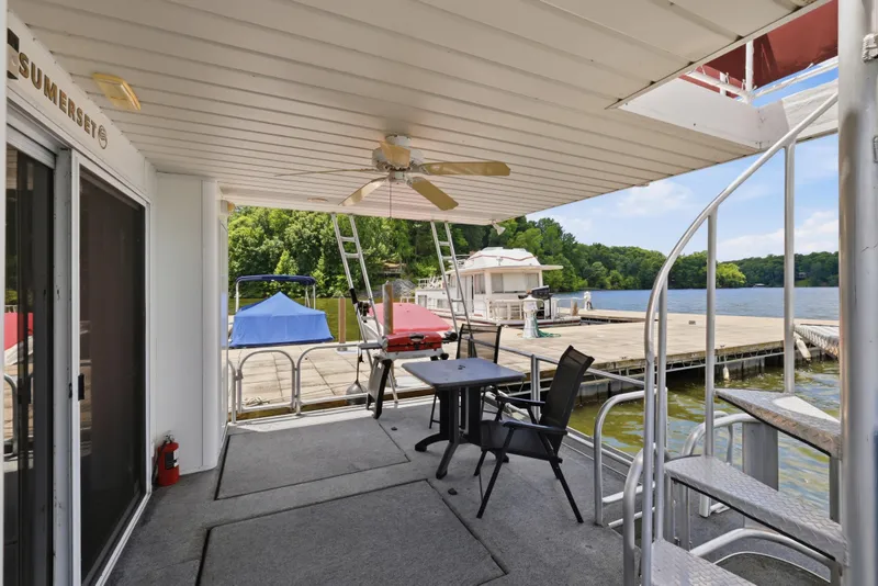 Slide: The Image of 2002 Sumerset 16x75 houseboat deck with seating, spiral staircase, and lake view. - 38