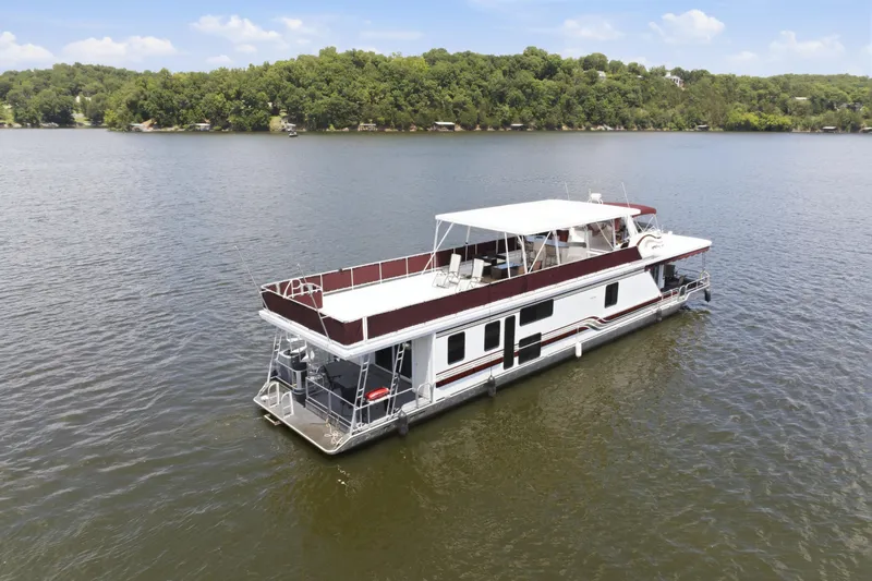 Slide: The Image of 2002 Sumerset 16x75 houseboat on a serene lake with lush green shoreline. - 11