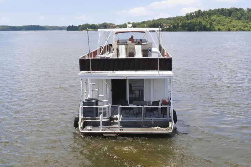 Slide: The Image of 2002 Sumerset 16x75 houseboat on a serene lake under a clear blue sky. - 3