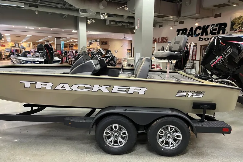 Slide: The Image of 2026 Tracker Savage 215 boat displayed indoors on a trailer. - 2