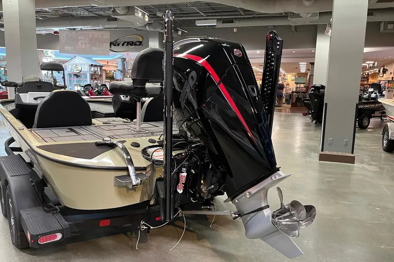 Slide: The Image of 2026 Tracker Savage 215 boat with powerful outboard motor in showroom. - 4