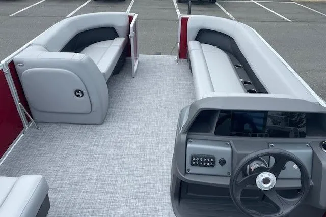 Slide: The Image of 2026 Sun Tracker Party Barge 18 DLX interior with gray seating and steering console. - 19