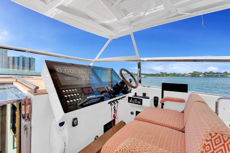 Slide: The Image of 2023 Delta Powerboats 60 Open helm with modern controls and waterfront view. - 25
