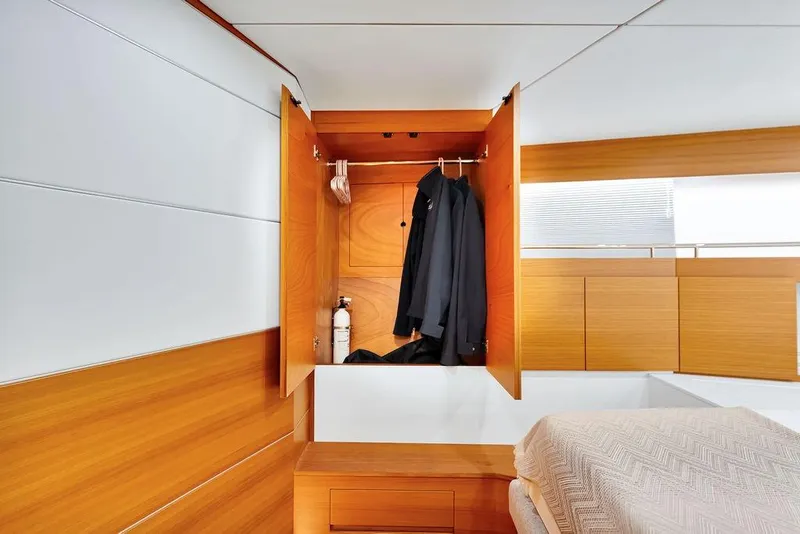 Slide: The Image of Interior of 2023 Delta Powerboats 60 Open, featuring a wooden wardrobe with hanging jackets. - 49