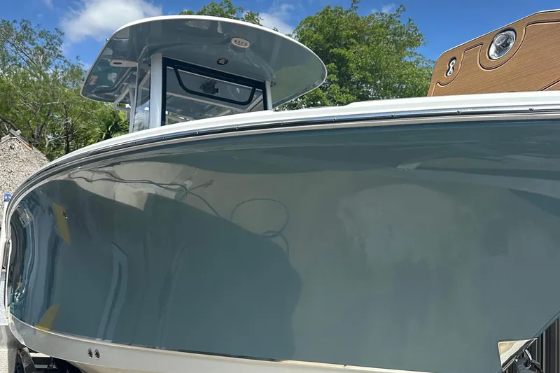 Slide: The Image of 2019 Sea Hunt Gamefish 25 boat with sleek design, docked under a clear blue sky. - 1