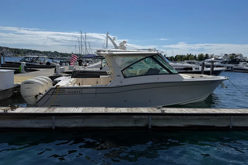 Slide: The Image of 2025 Grady-White Freedom 345 boat docked at marina under clear blue sky. - 1
