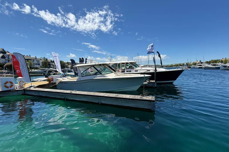 Slide: The Image of 2025 Grady-White Freedom 345 boat docked at a marina under clear blue skies. - 2
