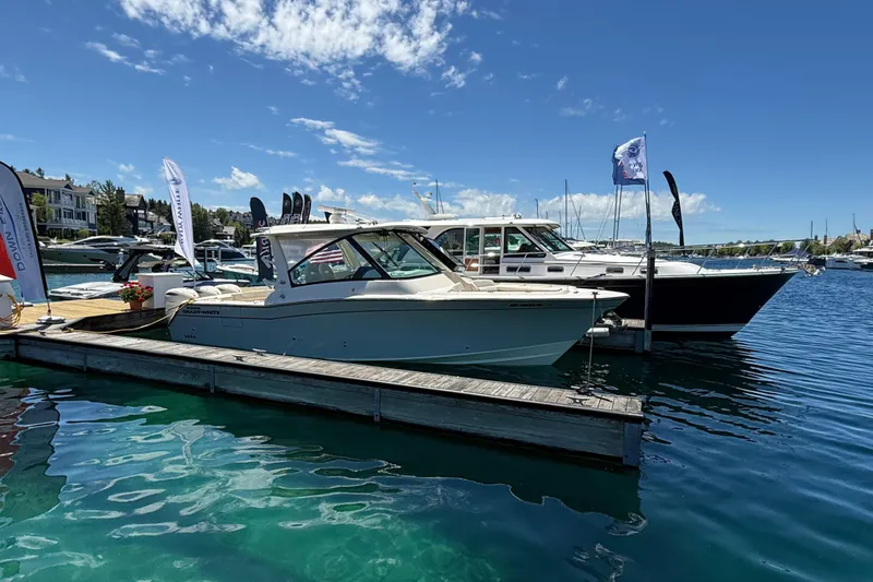 Slide: The Image of 2025 Grady-White Freedom 345 boat docked at marina under clear blue sky. - 3