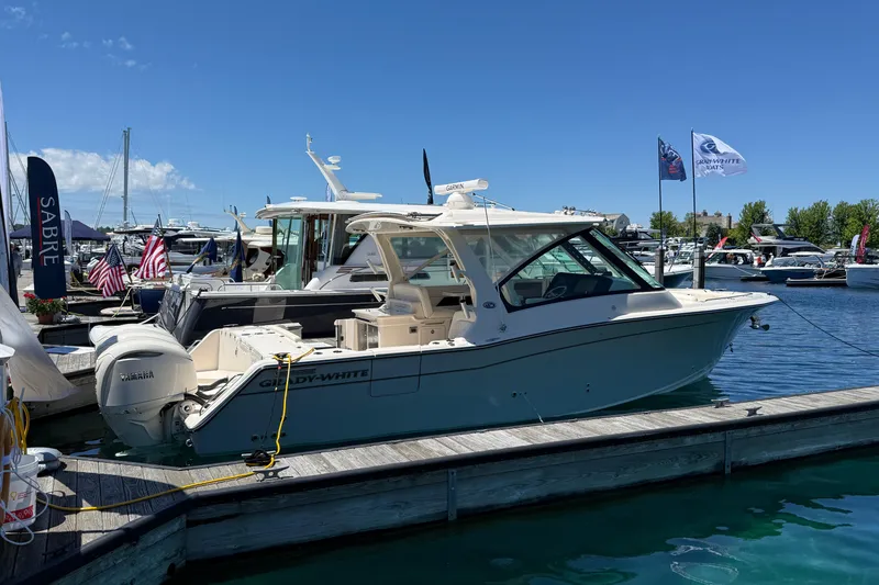 Slide: The Image of 2025 Grady-White Freedom 345 boat docked at marina under clear blue sky. - 4
