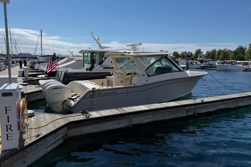 Slide: The Image of 2025 Grady-White Freedom 345 boat docked at marina under clear blue sky. - 5