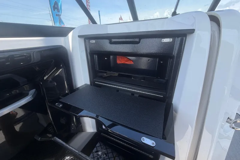 Slide: The Image of 2025 Yamaha Boats AR250 storage compartment with open hatch, showcasing interior design. - 28