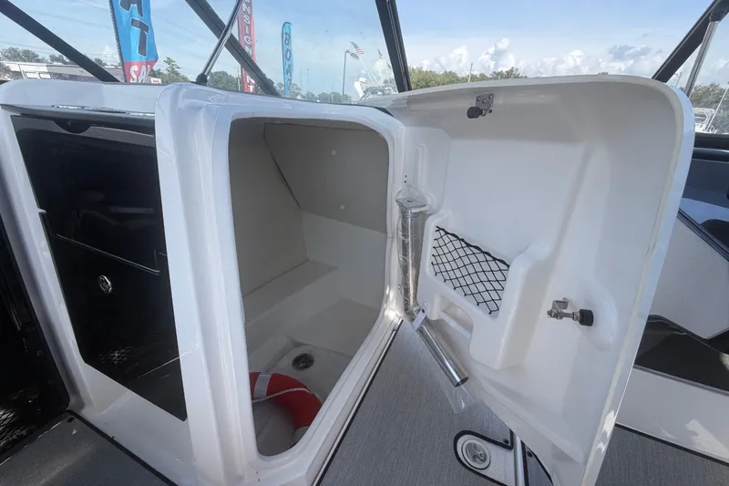 Slide: The Image of 2025 Yamaha Boats AR250 interior storage compartment with safety equipment. - 30