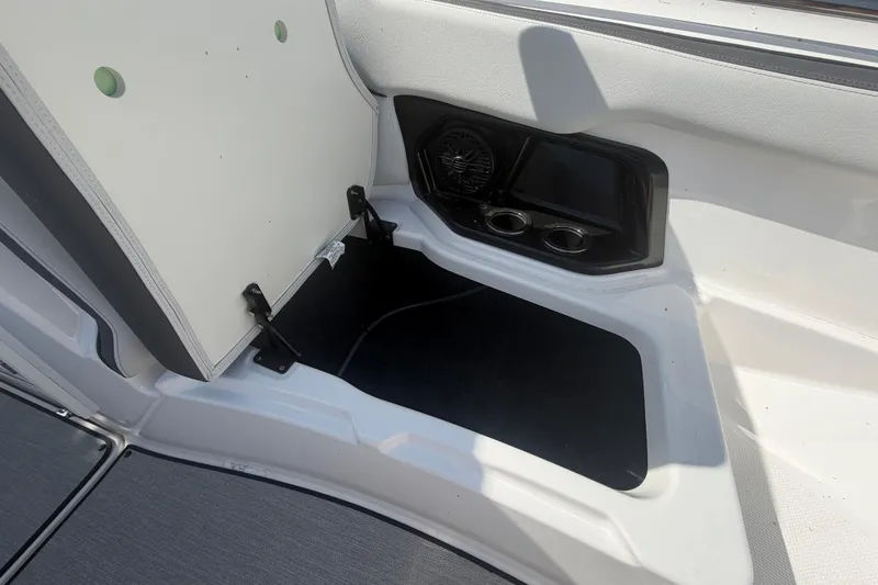 Slide: The Image of 2025 Yamaha Boats AR250 interior storage compartment with speaker and cup holders. - 36