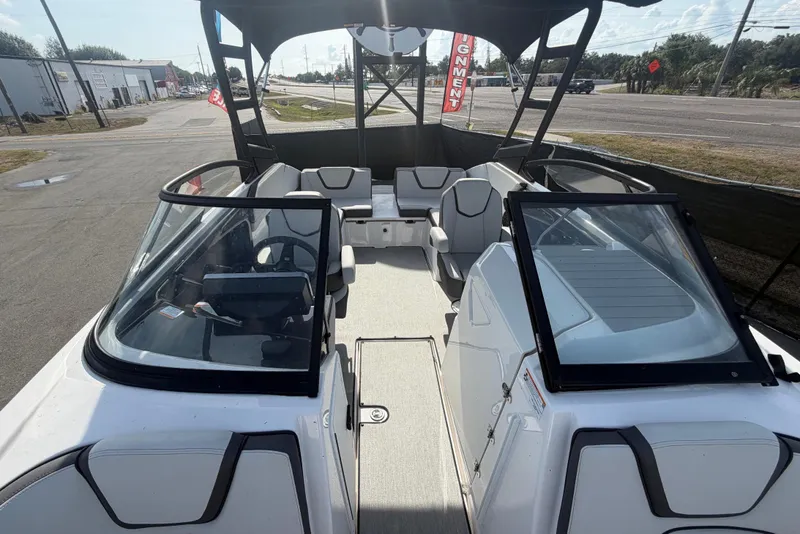 Slide: The Image of A modern Yamaha AR250 boat with open deck and seating, parked on land. - 42