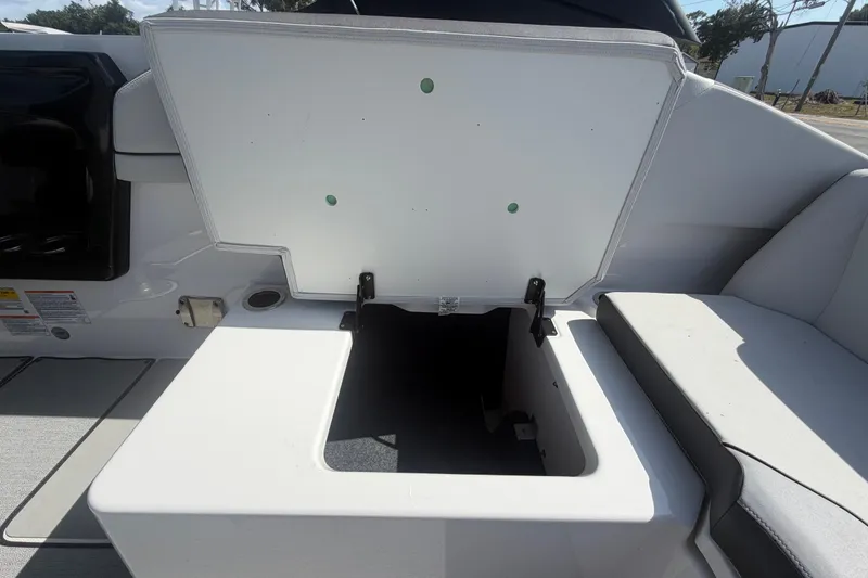 Slide: The Image of 2025 Yamaha Boats AR250 storage compartment with open lid, showcasing interior space. - 46
