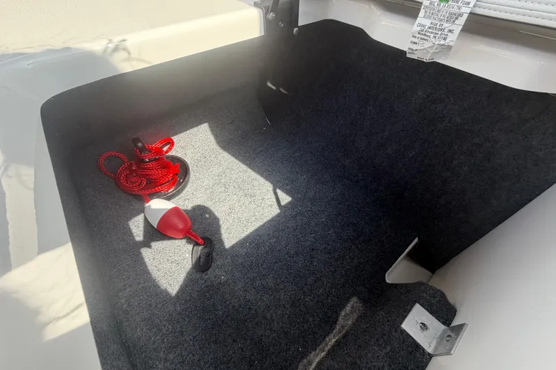 Slide: The Image of Storage compartment of 2025 Yamaha AR250 boat with red rope and float. - 47