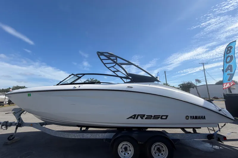 Slide: The Image of 2024 Yamaha AR250 boat on trailer under clear blue sky. - 6
