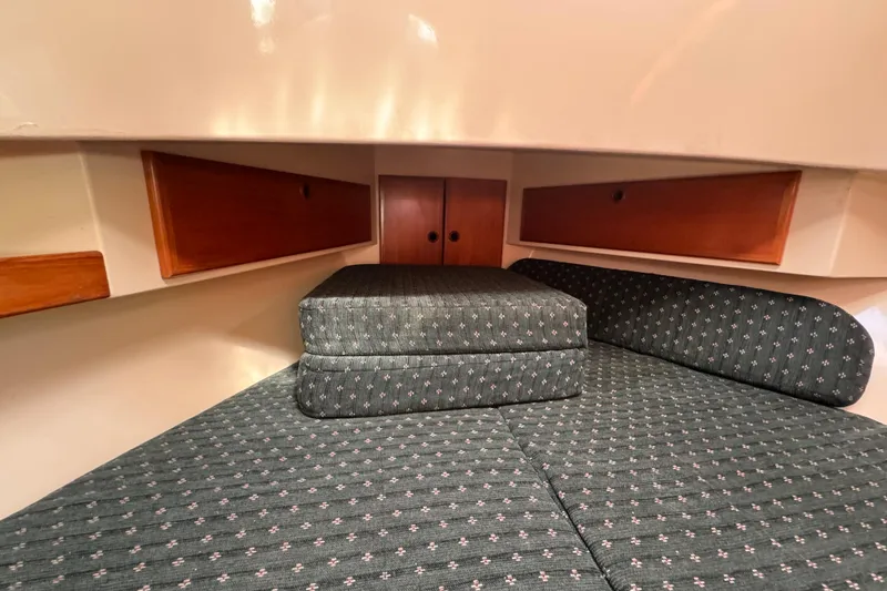 Slide: The Image of Cozy cabin interior of 1998 Pacific Seacraft Pilothouse 32 with cushioned seating and wooden storage. - 35