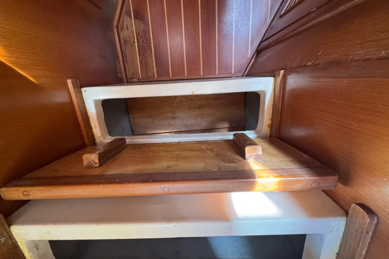 Slide: The Image of Interior view of 1998 Pacific Seacraft Pilothouse 32, showcasing wooden cabinetry and storage space. - 45