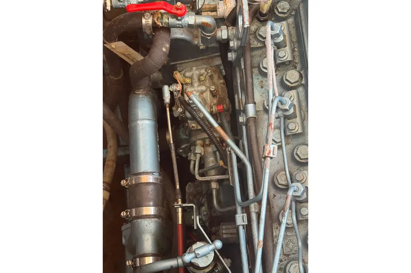 Slide: The Image of Engine components of a 1998 Transpacific Marine Pilothouse 32 boat, featuring pipes and bolts. - 51