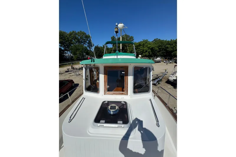 Slide: The Image of 1998 Pacific Seacraft Pilothouse 32 boat deck with green roof and clear sky. - 7