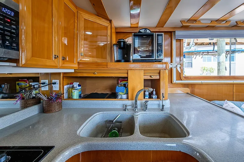 Slide: The Image of Luxurious kitchen interior of 2003 Magna Marine Nova Scotia 47 yacht, featuring wooden cabinetry and modern appliances. - 12