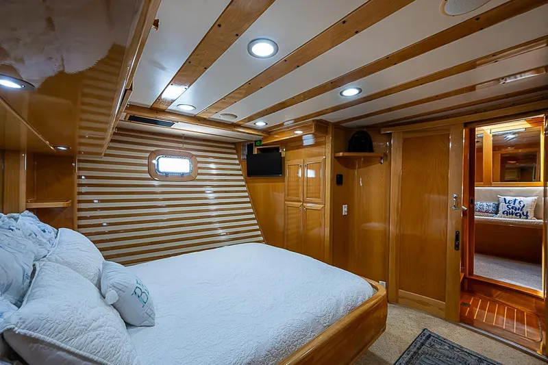 Slide: The Image of Luxurious cabin interior of 2003 Magna Marine Nova Scotia 47 yacht, featuring wood paneling and cozy bedding. - 20