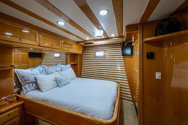 Slide: The Image of Luxurious cabin interior of 2003 Magna Marine Nova Scotia 47 yacht, featuring wood paneling and cozy bedding. - 23