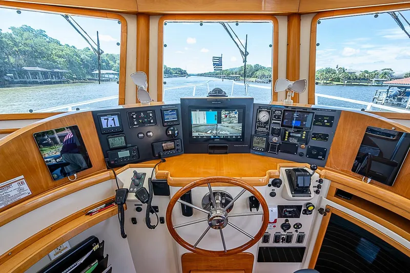 Slide: The Image of Helm of 2003 Magna Marine Nova Scotia 47 with navigation instruments and scenic river view. - 38