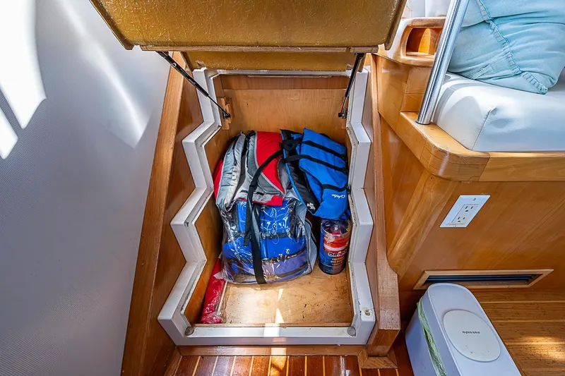 Slide: The Image of Storage compartment on 2003 Magna Marine Nova Scotia 47 boat with bags and a bottle. - 48