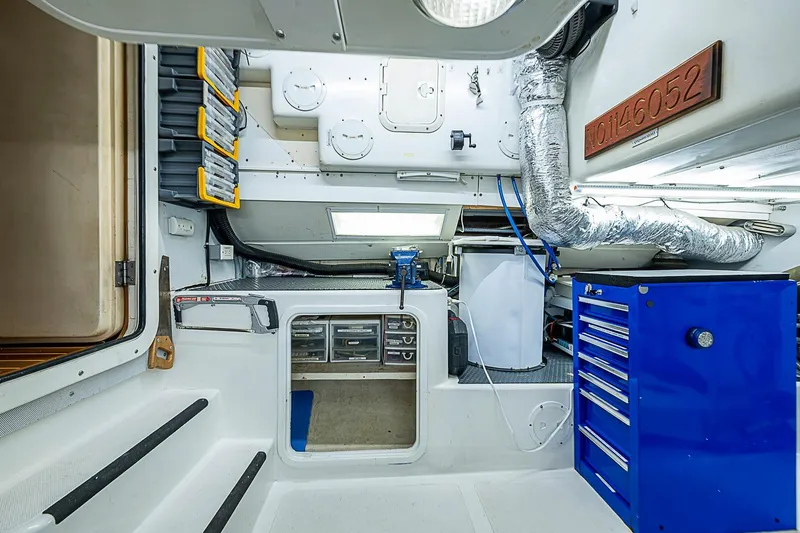 Slide: The Image of Engine room of 2003 Magna Marine Nova Scotia 47 with tools and storage compartments. - 56