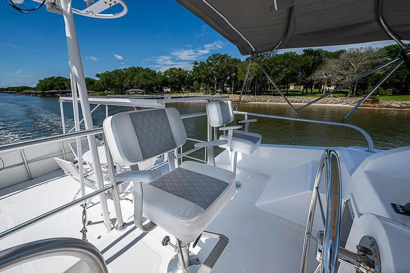Slide: The Image of Flybridge of 2003 Magna Marine Nova Scotia 47 yacht with helm chairs and scenic water view. - 66