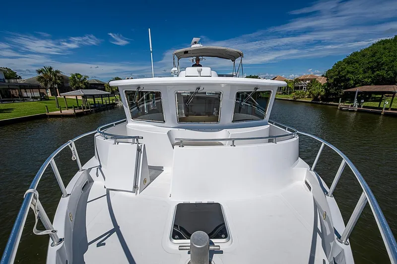 Slide: The Image of 2003 Magna Marine Nova Scotia 47 yacht on a serene waterway under a clear blue sky. - 75