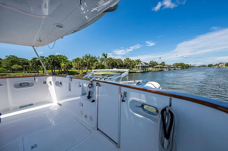 Slide: The Image of Magna Marine Nova Scotia 47 yacht deck, 2003 model, overlooking serene waterfront and lush greenery. - 78