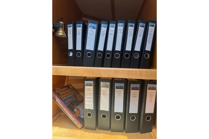 Slide: The Image of Shelves with organized binders and a book, related to Magna Marine Nova Scotia 47, 2003. - 83