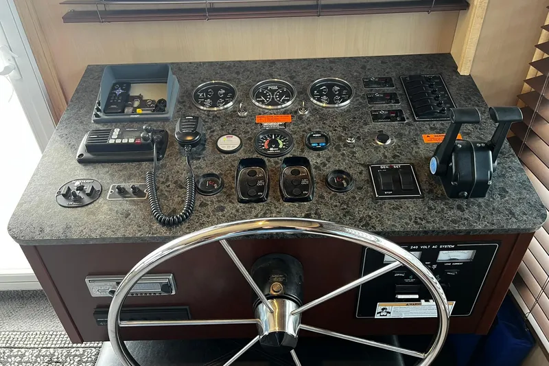 Slide: The Image of Control panel of a 2010 Skipperliner 480 Flybridge with steering wheel and navigation instruments. - 15