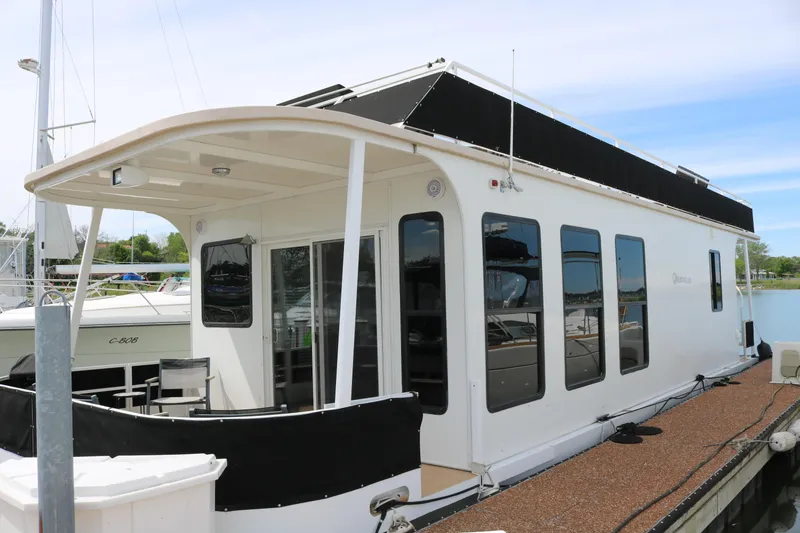 Slide: The Image of 2010 Skipperliner 480 Flybridge docked, featuring sleek design and spacious deck area. - 2