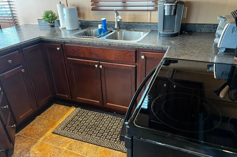 Slide: The Image of Modern kitchen on 2010 Skipperliner 480 Flybridge with dark wood cabinets and appliances. - 29