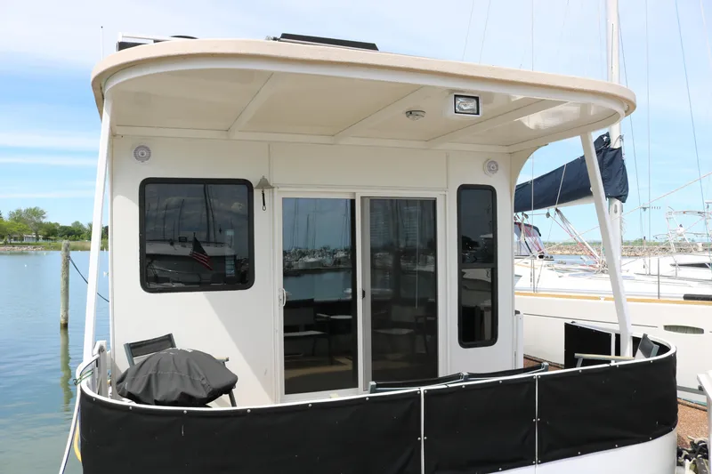 Slide: The Image of 2010 Skipperliner 480 Flybridge docked, featuring a covered deck and sliding glass doors. - 3
