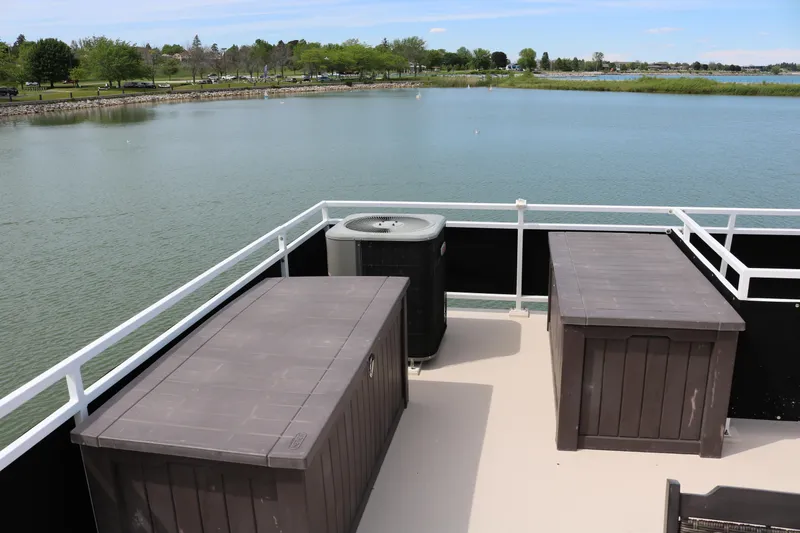 Slide: The Image of Flybridge deck of 2010 Skipperliner 480 with storage boxes, overlooking serene lake view. - 41