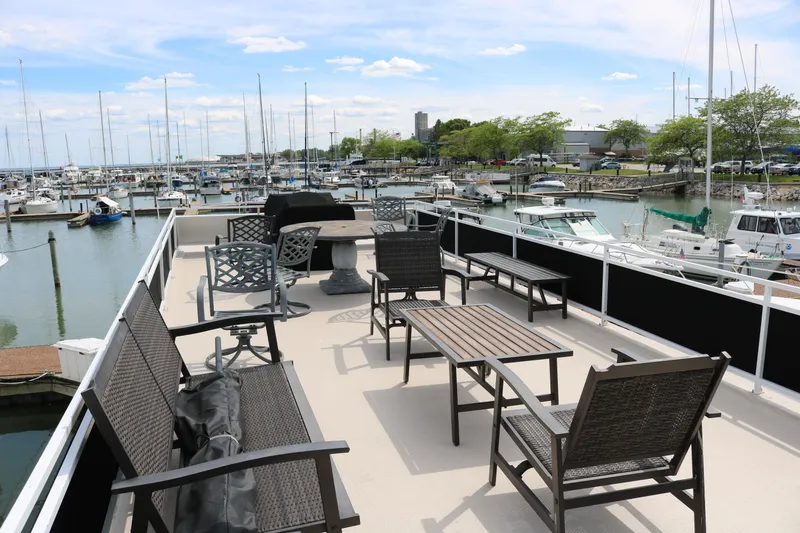 Slide: The Image of Flybridge deck of 2010 Skipperliner 480, overlooking marina with seating and tables. - 43