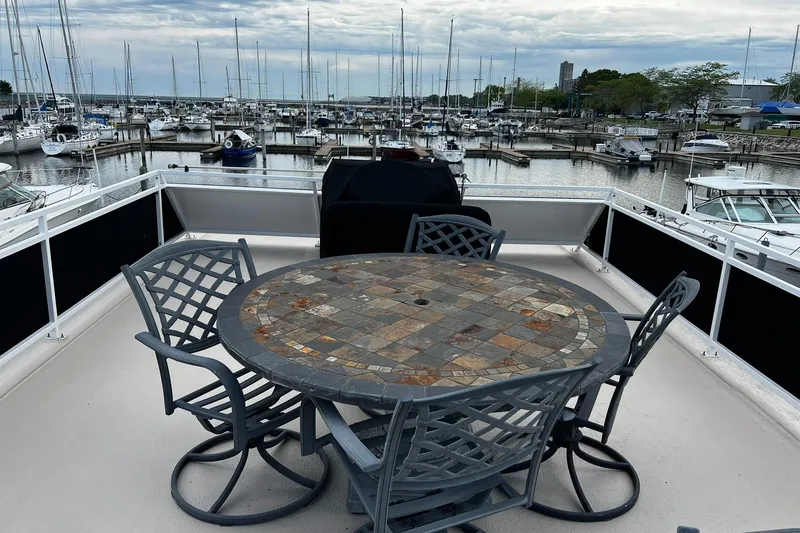 Slide: The Image of Flybridge of 2010 Skipperliner 480 with mosaic table, overlooking marina with docked boats. - 48