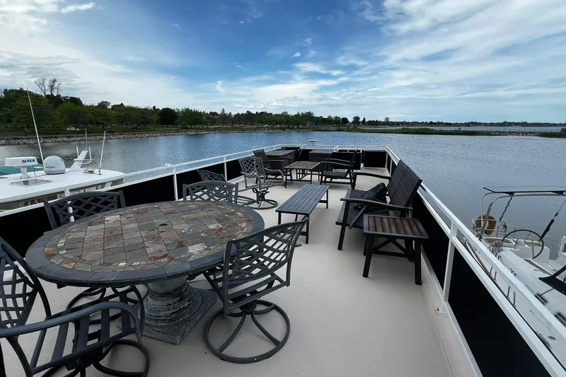Slide: The Image of Flybridge deck of 2010 Skipperliner 480 with seating, overlooking serene water and lush shoreline. - 49