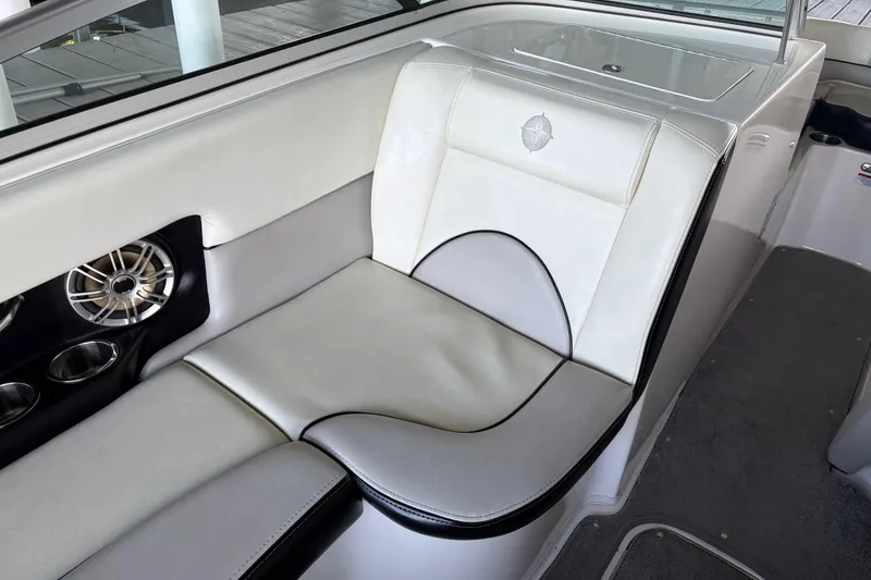 Slide: The Image of Luxurious seating in a 2013 Bryant 210 Walkabout boat, featuring white upholstery and speaker system. - 6