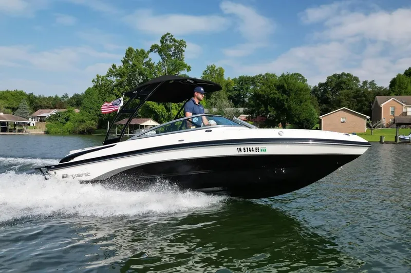 Slide: The Image of 2013 Bryant 210 Walkabout boat cruising on a lake with a person steering. - 4