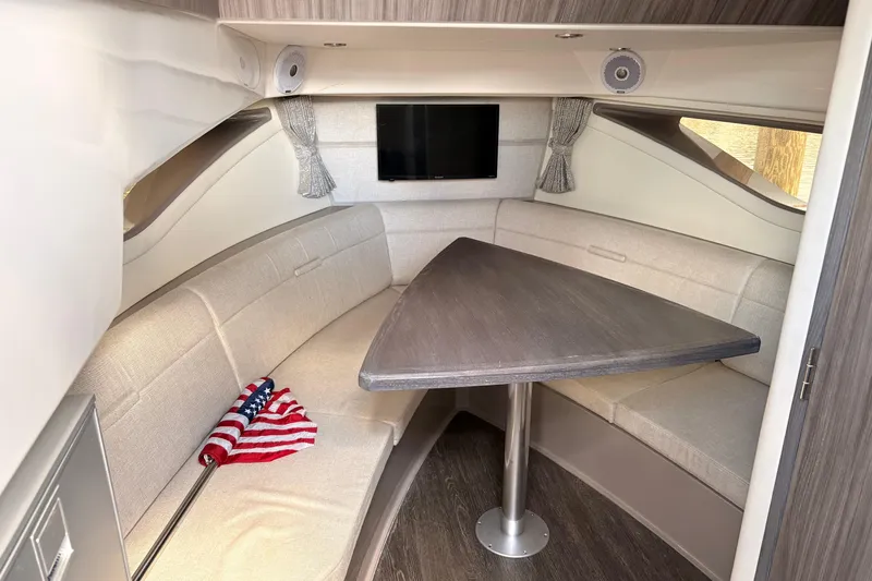 Slide: The Image of Interior of 2019 Sea Ray Sundancer 320 with seating, table, and American flag. - 13