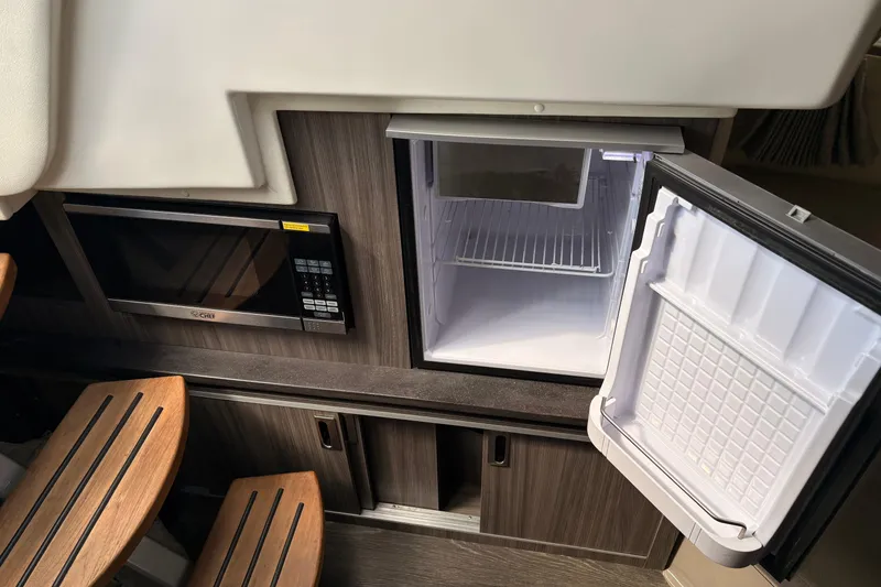Slide: The Image of 2019 Sea Ray Sundancer 320 interior with microwave and open refrigerator. - 14
