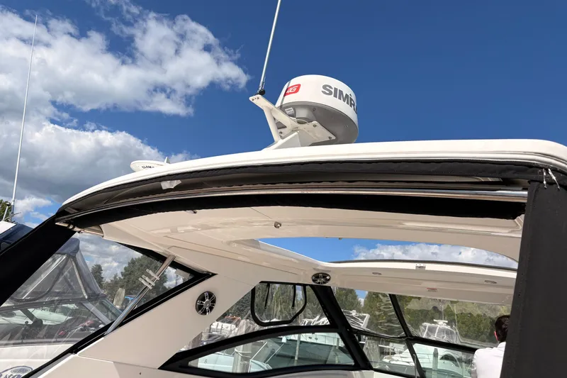 Slide: The Image of 2019 Sea Ray Sundancer 320 boat with radar, under clear blue sky. - 16