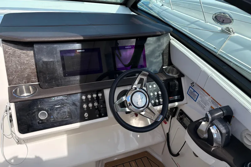 Slide: The Image of 2019 Sea Ray Sundancer 320 helm with modern controls and navigation displays. - 17
